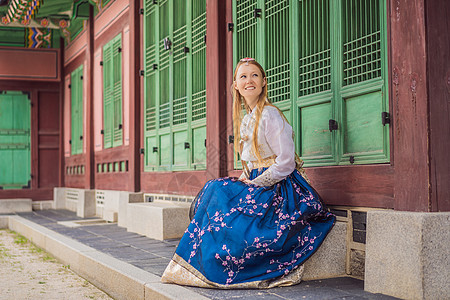 在韩国宫殿穿着韩服的年轻白人女游客 前往韩国的概念 韩国民族服装 游客娱乐试穿韩国民族服饰城市建筑地标女性传统国家女士女孩花园裙图片