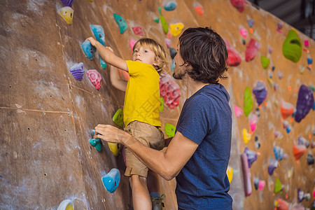 爸爸和儿子在攀岩墙 家庭运动 健康生活方式 幸福家庭教学游戏安全婴儿挑战孩子活动父亲社论比赛图片