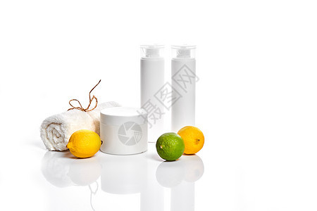 白色瓶子和两个整个柠檬和石灰隔离在白色背景 广告化妆品的概念家务橘味液体浴室添加剂团体水果软木淋浴洗澡图片
