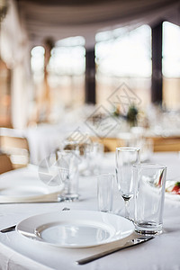 为活动派对或婚宴布置的餐桌 宴会桌设计 节日餐桌布置 桌子上的玻璃和盘子婚姻风格接待餐厅环境服务舞会装饰椅子花束图片