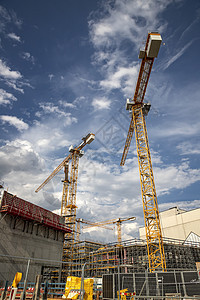 用起重机和建筑对施工工地的日视图 垂直视图项目基础设施建筑学脚手架蓝色财产摩天大楼工作机器天空图片