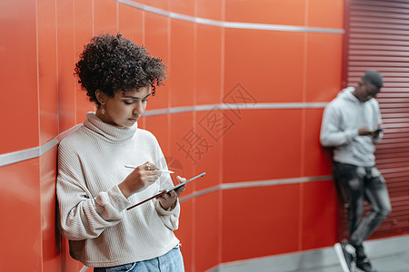 微笑的年轻女子与数字平板电脑站在地铁上图片