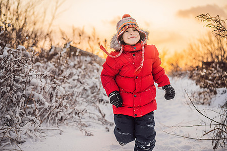 穿红冬服的可爱男孩在雪中玩得很开心 冬季乐趣出门概念幸福男生新年孩子雪花婴儿围巾家庭女孩儿子图片
