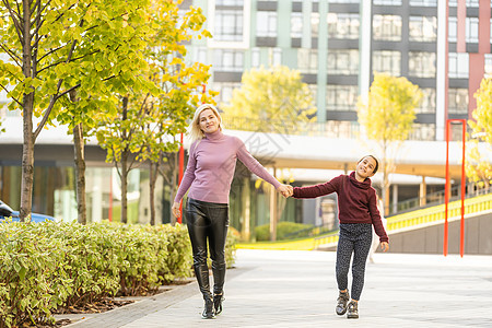母亲与女儿在秋天小巷成人感恩牛仔裤青年叶子童年靴子牛仔布情感婴儿图片