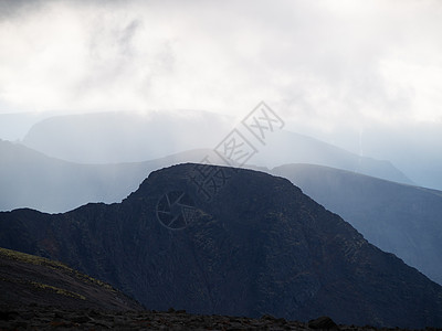 云层中的山峰 背光下一连串灰色山脉丘陵仙境比丘旅行基岩射线季节地质学墨水太阳图片