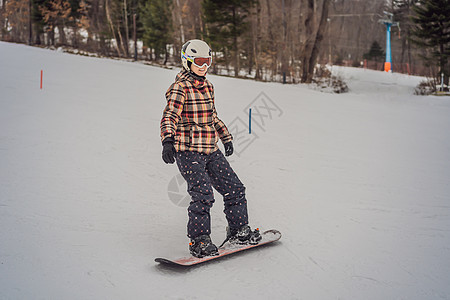 在滑雪度假胜地的阳光明媚的冬日季节粉末娱乐女性衣服运动单板成人女孩乐趣图片