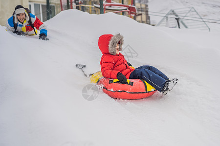 孩子在雪地上玩儿得开心 男孩骑着浴缸 孩子们过冬乐趣幸福雪管假期娱乐运动滑雪闲暇季节速度男人图片