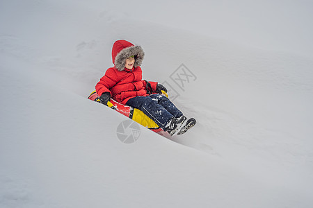 孩子在雪地上玩儿得开心 男孩骑着浴缸 孩子们过冬乐趣女性公园晴天假期速度雪管闲暇季节爬坡雪橇图片