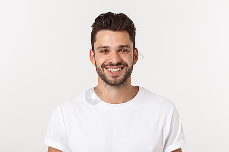 在黄色背景下微笑的英俊年轻男子的肖像相机衬衫男性白色幸福人士头发蓝色商务快乐图片