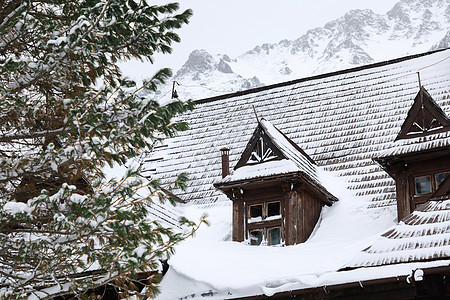 山上旧木屋的屋顶被雪覆盖图片