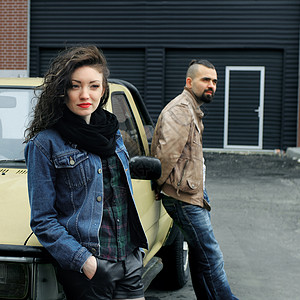 年轻女子和男友站在车旁的汽车旁边图片