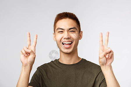 人 不同的表达方式和生活方式的概念 特写快乐英俊的年轻男学生 日本人感到乐观 准备度假 表现出和平迹象 微笑快乐员工旅行成人技术图片
