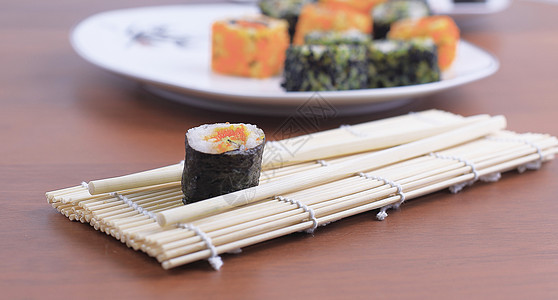 木制桌上的寿司卷和筷子鱼片海鲜饮食蔬菜海藻美味黄瓜小吃餐厅大豆图片