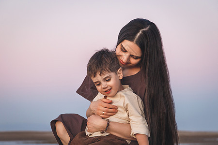 一个年轻母亲和她儿子的画像 日落室外金色时钟拍攝图片