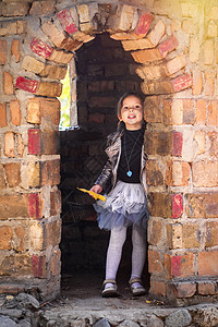 穿着时尚秋衣的可爱小姑娘 在石城堡塔楼玩耍图片