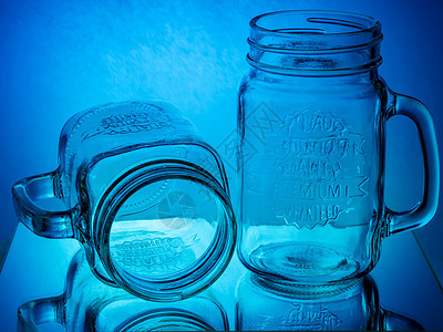蓝色和红色发光背景的玻璃罐杯杯脆弱性艺术器皿反射水晶乡村描绘奶昔空白食物图片