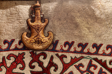 马奶酒Torsyk - 哈萨克斯坦国家饮料集装箱 在以亚洲中部形态的地毯背景上装有土耳其装饰品的饮料背景