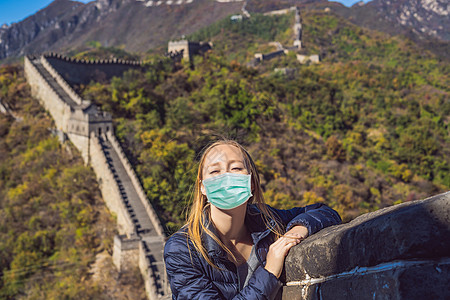 戴着医用面具在中国长城的女游客 女孩参观和观光中国目的地 游客害怕 2019-ncov 病毒 医疗蒙面游客图片