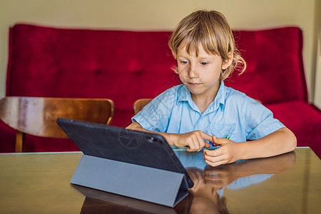 男孩使用平板电脑在家网上学习 在隔离期间学习 全球大流行共生19病毒孩子互联网感染消毒剂肺炎教育微笑父亲警报男生图片