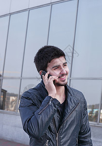 青年男子在街上用手机说话图片