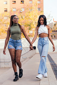 年轻黑人女子夫妇牵手散步的情侣图片