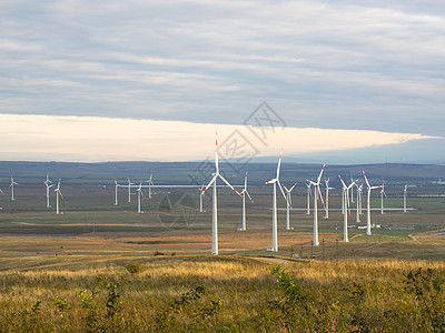 风力涡轮机位于山丘上生态白色风险草原涡轮农场螺旋桨旅行天空发电机图片