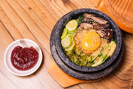 韩国传统菜盘比宾巴混合米和蔬菜包括牛肉和炒蛋桌子石头菠菜餐厅盘子蛋黄猪肉食谱烹饪美食图片