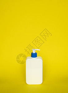 凝胶 乳液 面霜 洗发水 沐浴露的液体容器 黄色背景上带蓝色分配器泵的化妆品塑料瓶 带复制空间的化妆品包装模型图片