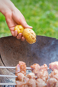 男人准备烧烤肉和土豆餐饮厨房蔬菜鱼片营养团体自助餐火盆牛扒网格图片