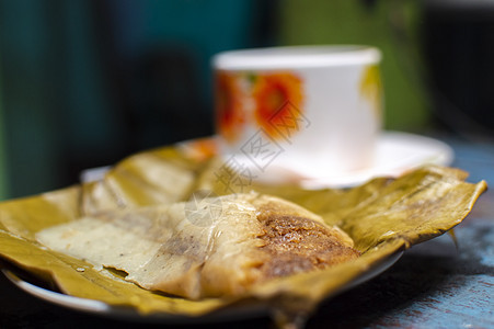 木制餐桌 香蕉叶上塞满的塔马人 木制餐桌 典型的尼卡拉瓜食品早餐美食面包盘子蒸肉食物玉米烹饪叶子图片