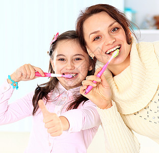 母亲和女儿刷牙展示微笑童年快乐女性父母福利女孩亲戚们牙刷图片