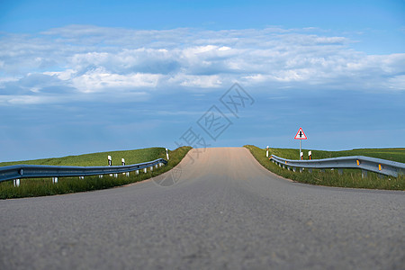 穿过平草绿田的荒漠道路图片