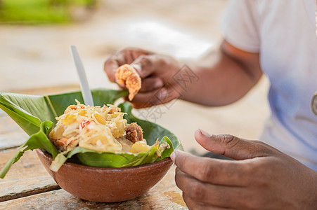 近距离接近一个人吃维哥伦人 在木制桌上吃维哥伦人食品活力民族沙拉丝兰早餐猪皮食物东西图片