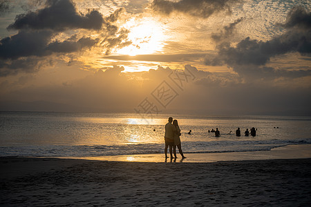 日落黄昏时分 浪漫情侣在海滩上欣赏日落的轮廓 在哈夫洛克安达曼 海浪拍打着海岸图片