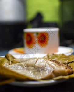 木制餐桌 香蕉叶上塞满的塔马人 木制餐桌 典型的尼卡拉瓜食品面包早餐盘子食物叶子蒸肉玉米烹饪美食图片