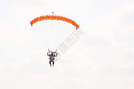 Skydiver 背景上有一小块降落伞的树冠 蓝色天空 近距离特写 在降落伞下Skydiver绳索行动飞行员肾上腺素空气领航天篷图片