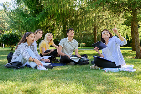 户外 有女教师坐在草地上的学生群体朋友们瞳孔男性团体中学公园女孩校园女士孩子图片