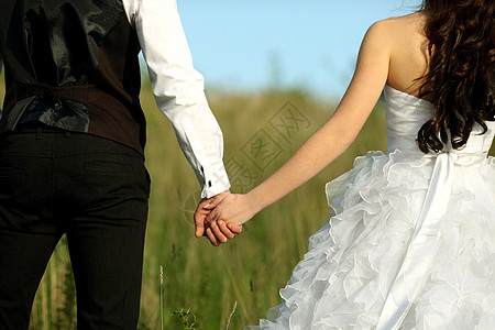 穿着白色礼服的新娘和身穿西装的新郎后视镜 将双手举起在户外婚姻女士男性婚纱裙子婚礼男人生活仪式庆典图片