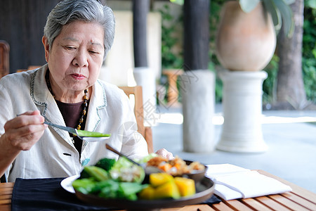 老年年长老年妇女食用食物 成熟退休的生活方式和生活习惯成人午餐用餐女士祖母女性餐厅美食背景图片