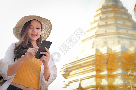 携带背背背包使用移动智能电话的女旅行者 旅费旅行概念手机互联网旅游技术女性游客女士图片