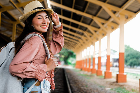 在火车站背着背包的女人背包客旅行者 旅行旅行概念火车女士帽子平台女性车站运输游客铁路生活图片