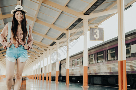 在火车站背着背包的女人背包客旅行者 旅行旅行概念游客铁路平台火车女士女性生活帽子运输车站图片