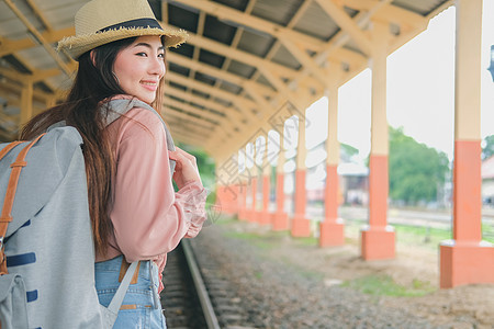 在火车站背着背包的女人背包客旅行者 旅行旅行概念女性运输火车帽子铁路生活车站游客女士平台图片