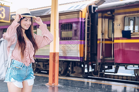 在火车站背着背包的女人背包客旅行者 旅行旅行概念铁路平台运输女士车站女性火车帽子生活游客图片