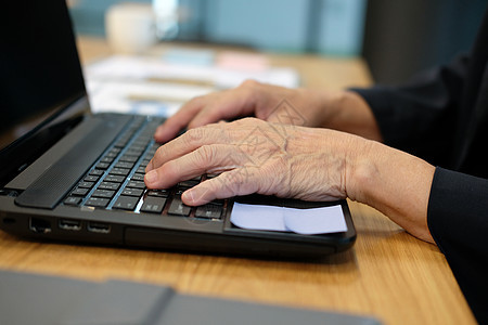 在家庭办公室工作的计算机膝上型电脑键盘上的手打字女性女士互联网工人手指桌子职场电子产品技术商务图片