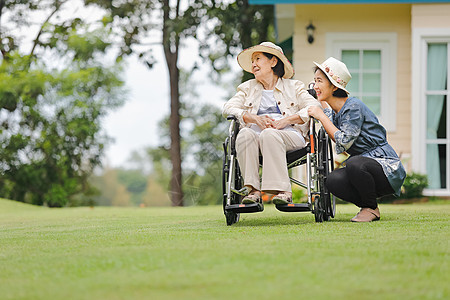 老年妇女与女儿一起在后院轮椅上放松帮助女性人士卫生保健治疗照顾者残障骨科祖母图片