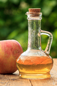 玻璃瓶中的苹果醋和木板上新鲜的红苹果水果食物桌子乡村红色绿色玻璃液体瓶子果汁图片