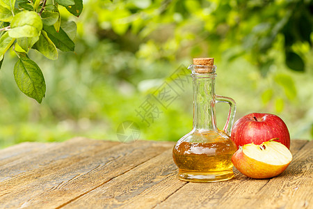 玻璃瓶中的苹果醋和木板上新鲜的红苹果液体水果绿色食物桌子玻璃瓶子果汁乡村红色图片