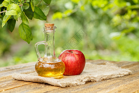玻璃瓶中的苹果醋和木板上新鲜的红苹果红色乡村水果果汁瓶子玻璃液体食物桌子绿色图片
