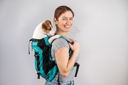 白种女人背着杰克罗瑟尔的狗冒险婴儿车篮子小狗工作室女性宠物袋鼠动物犬类图片